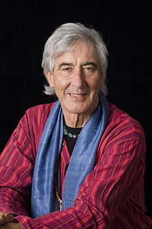 imagem informativa José Argüelles sorrindo para a câmera com um fundo preto.