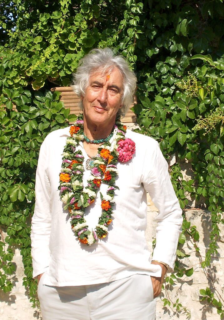 imagem informativa José Argüelles vestindo roupas brancas e colares de flores na Itália em 2009.